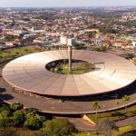 Vista aérea de um terminal rodoviário com ônibus, edifícios e a paisagem urbana ao redor