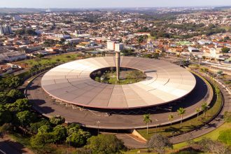 Vista aérea de um terminal rodoviário com ônibus, edifícios e a paisagem urbana ao redor