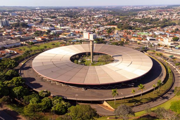 Vista aérea de um terminal rodoviário com ônibus, edifícios e a paisagem urbana ao redor